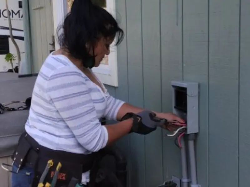Licensed electrician wiring an exterior subpanel in Gray
