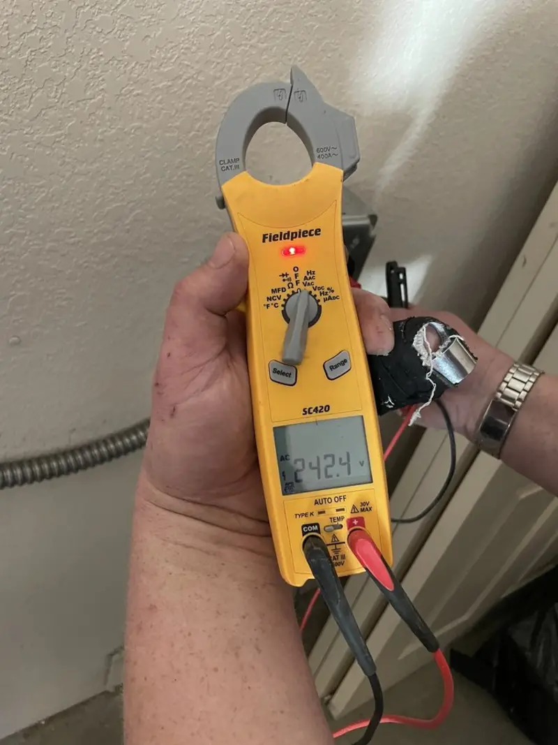 Voltage testing with clamp meter during Ceiling Fan Installation in Gray